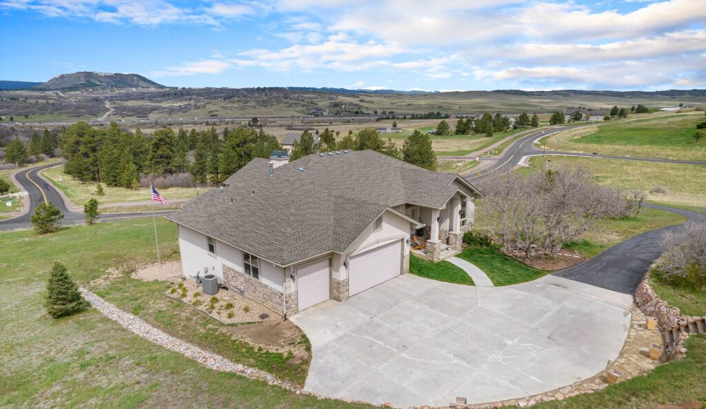 Aerial view of a ranch home on Bell Mountain Drive in Bell Mountain Ranch with Castle Rock buttes in the distance