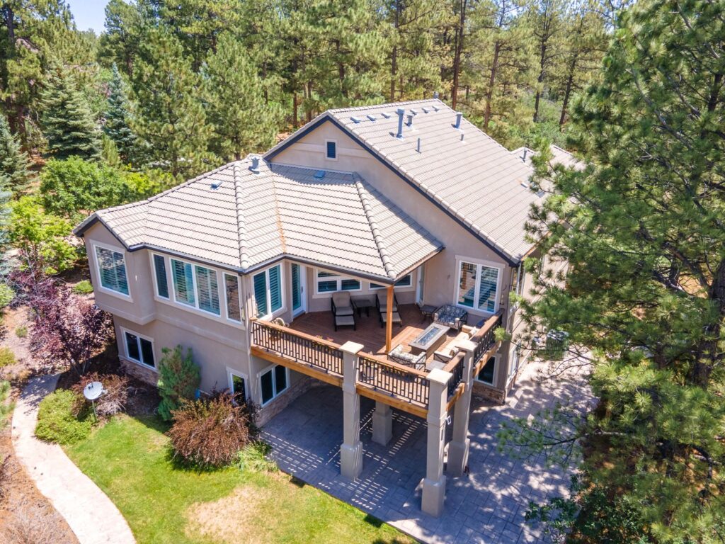 Aerial view of an acreage home among ponderosa pines in Franktown, CO, sold by the Joan Pratt Group