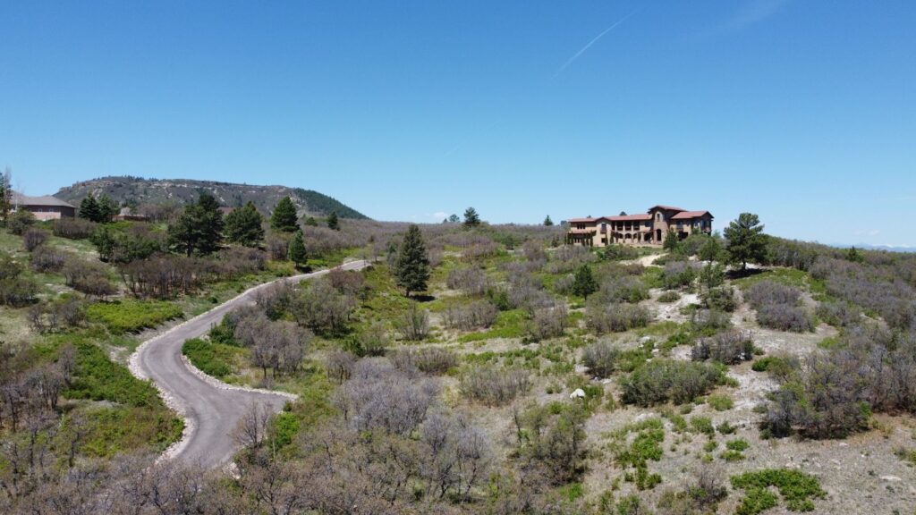Aerial view of acreage and a hilltop home on Colt Circle in Keene Ranch with Castle Rock views